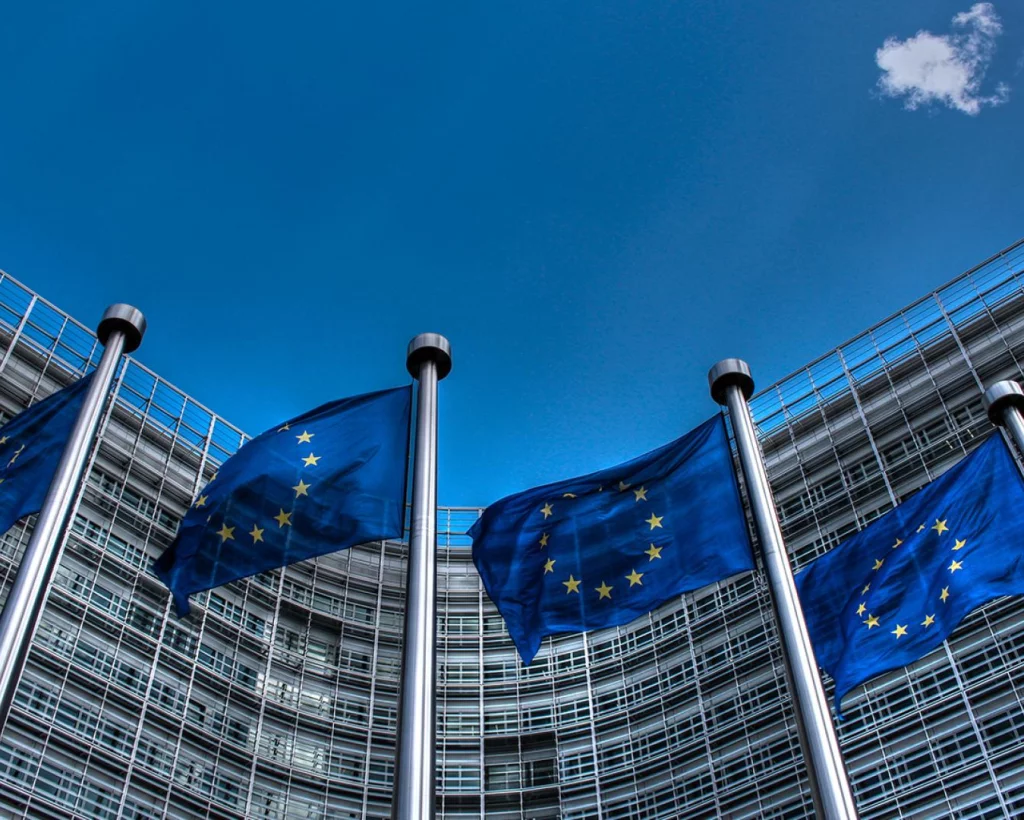 Flagi Unii Europejskiej powiewające przed budynkiem Komisji Europejskiej
